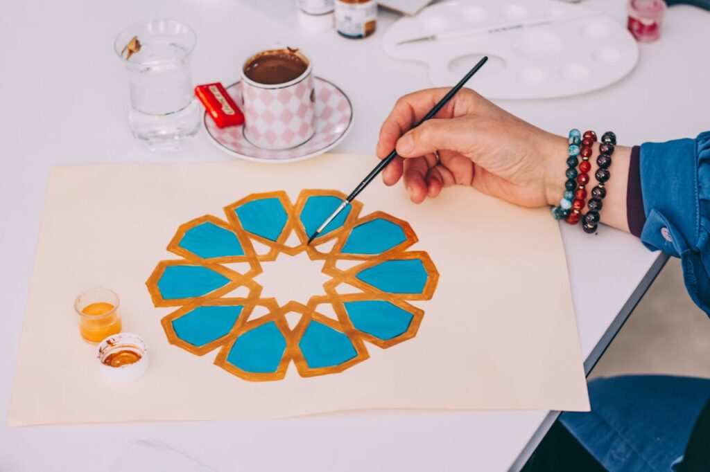 pexels-photo-30567260 Hand painting of a geometric Islamic pattern on paper, featuring vibrant colors.